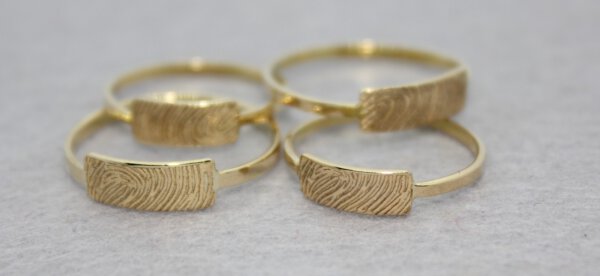 ringen van omgesmolten goud van mamma, met gravure van vingerafdruk van pappa en mamma
