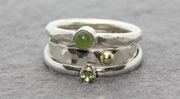 stapelringen in zilver met gouden details en een nefriet en peridot
