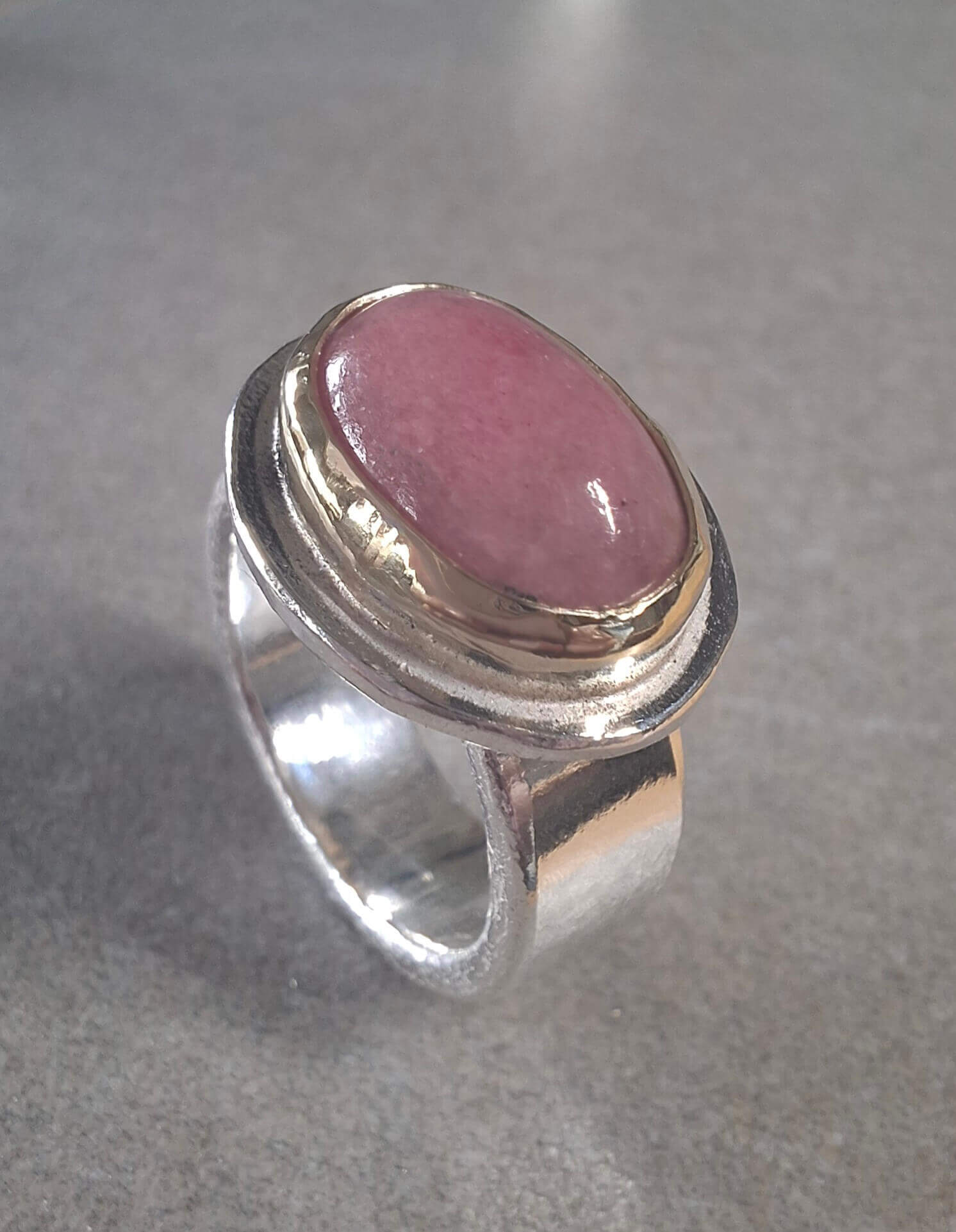 Zilveren ring met goud gezette rhodochrosiet steen van 15x11 mm, brede band 7 mm.