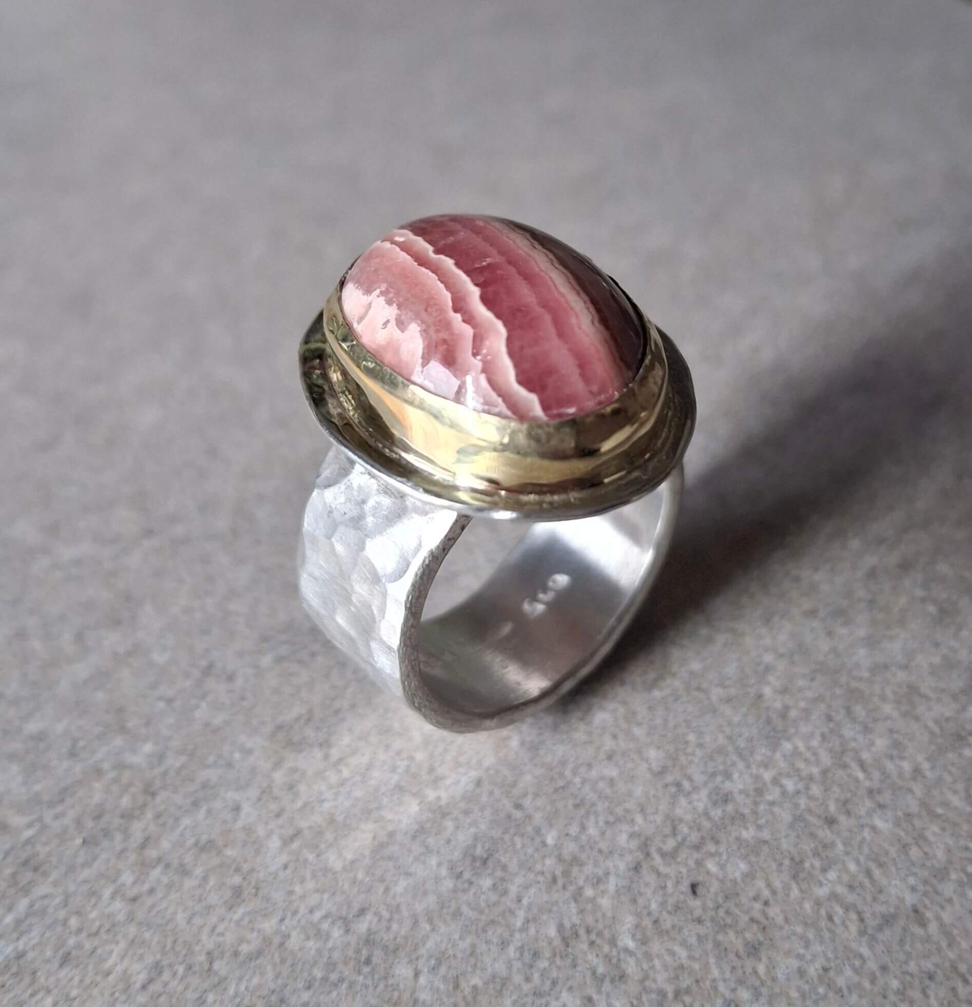 Zilveren rhodochrosiet ring met goud gezette steen, brede band