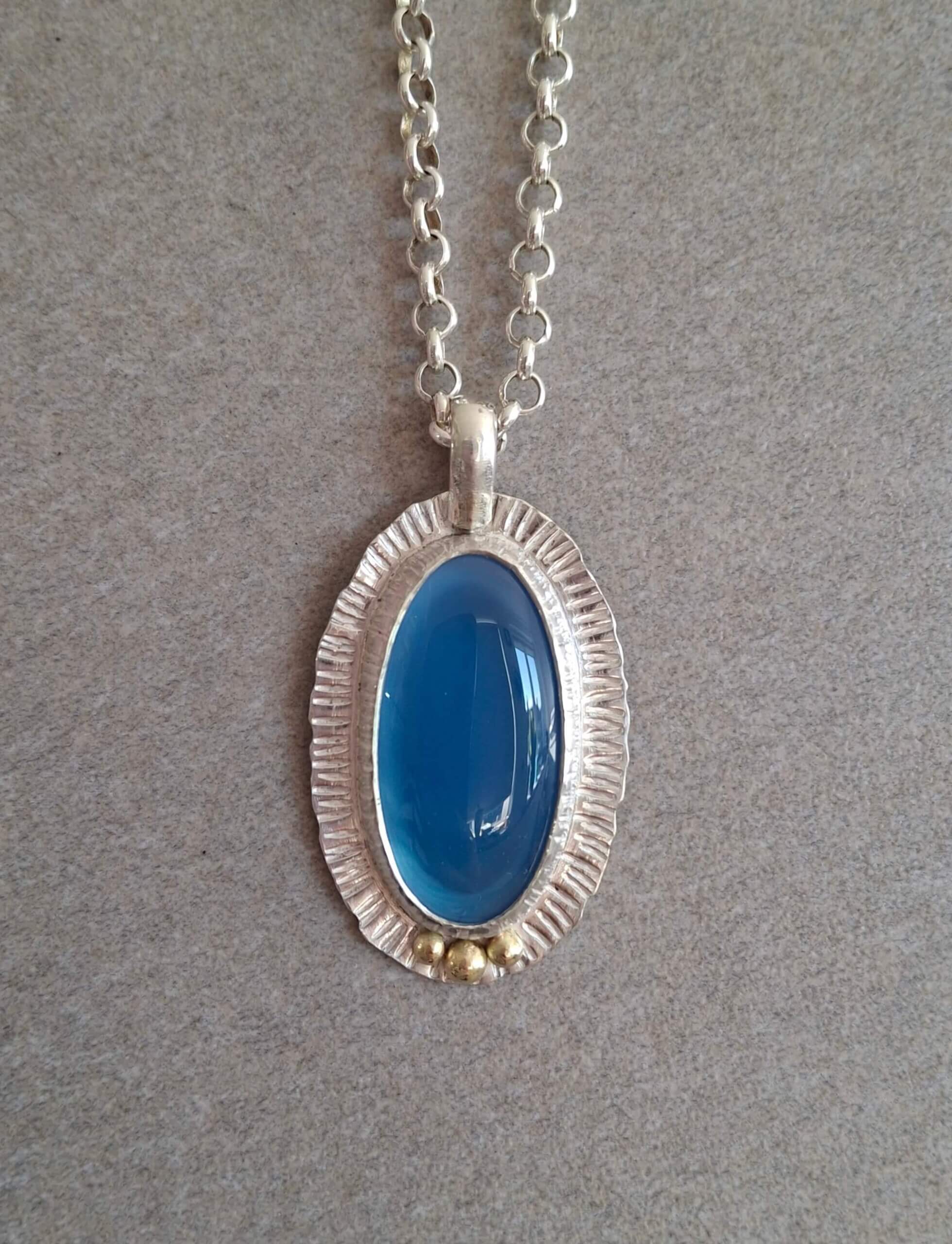 Zilveren hanger met peervormige rozenkwarts en gouden accent, 40 mm.